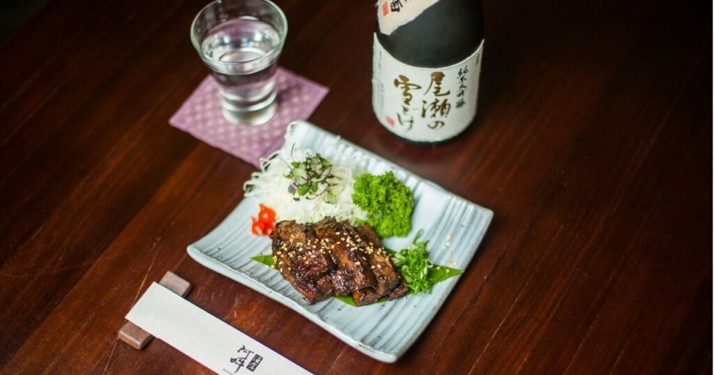 グラスに注がれた冷酒と焼き物。