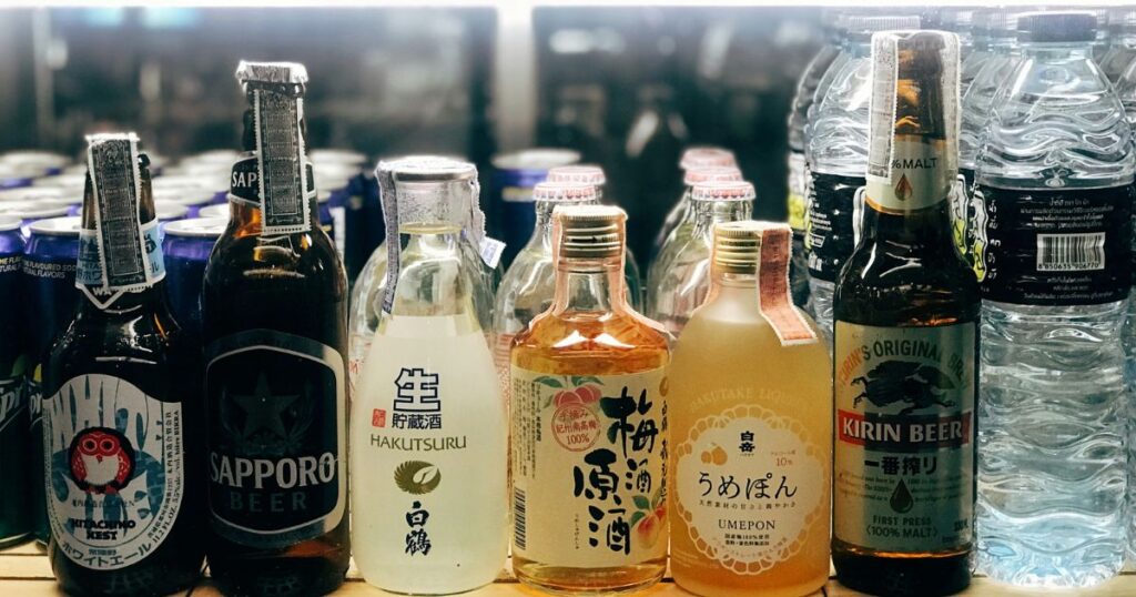 棚に陳列された数種類のお酒の瓶。
ビール、日本酒、梅酒など。