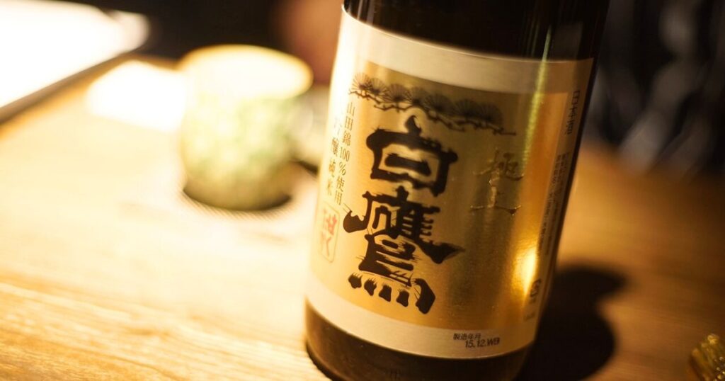 テーブルに置かれた日本酒（白鷹）の一升瓶。